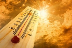 Thermometer displaying high temperatures against a bright, sunny sky, symbolizing the need for optimal air conditioning settings in Florida's summer heat.