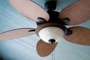 Ceiling fan with wooden blades, enhancing air circulation for energy-efficient cooling in homes.