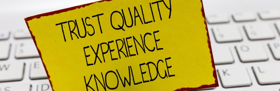Trust quality experience knowledge on a yellow sticky note placed on a keyboard, emphasizing the importance of commitment to HVAC service plans.