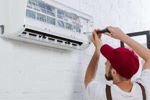 Technician changing air filter in HVAC unit, emphasizing importance of regular maintenance for improved indoor air quality.