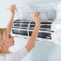 Woman cleaning air filter of an HVAC unit, emphasizing maintenance for healthy air quality and system longevity.