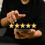 Person using smartphone to rate HVAC services with five gold stars, reflecting customer satisfaction for Mid Florida A/C.