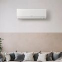 Ductless mini-split air conditioning unit mounted on a wall above a stylish sofa, illustrating modern HVAC solutions for home comfort.